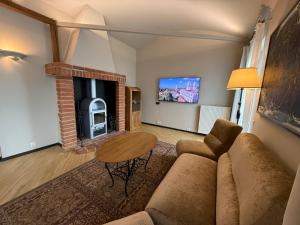 a living room with a couch and a table and a fireplace at BEST WESTERN Santakos Hotel in Kaunas