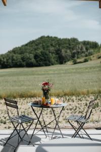 a table with a vase of flowers and two chairs at Casa Praie in Casasco