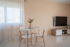 a dining room with a table with chairs and a vase with flowers at Kos Happy living in Lampi