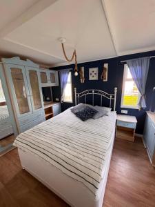 a bedroom with a large bed and blue walls at Między polami in Drewnica