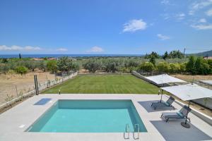 a swimming pool with two chairs and an umbrella at Apex Premium Living in Leptokarya
