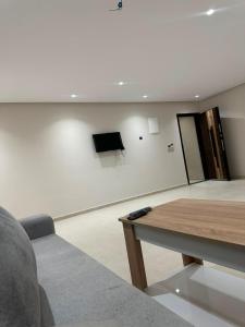 a living room with a couch and a tv on a wall at Igar Azougagh Immeuble DII in Al Hoceïma