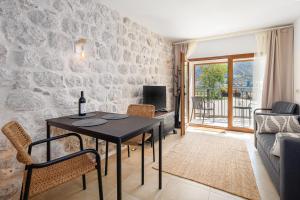 a living room with a table and chairs and a couch at Historic Waterfront Apartment in Muo