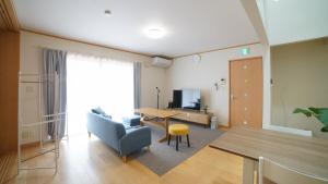 a living room with a table and a couch and a tv at maison de plum in Nasushiobara