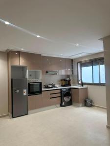 a large kitchen with stainless steel appliances in an empty room at Igar Azougagh Immeuble DII in Al Hoceïma +59 photos