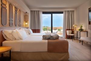 a bedroom with a large bed and a living room at Barceló Tenerife Royal Level in San Miguel de Abona