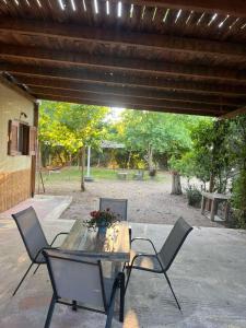 a wooden table and four chairs under a patio at Amarynthos Tiny Retreat in Amarynthos