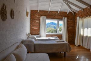 a room with three beds and a large window at Hostería La Viña in La Cumbre +134 photos