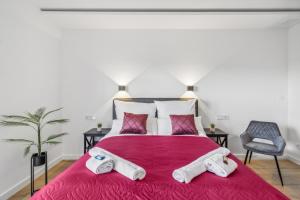 a bedroom with a large red bed with towels on it at Serviced Apartments Suite4Me in Dietzenbach