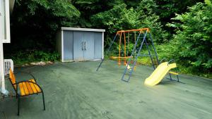 a playground with two swings and a slide at maison de plum in Nasushiobara