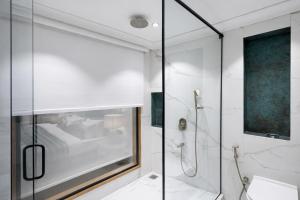 a bathroom with a shower with a glass door at AB's Abode-A Boutique Hotel in Mussoorie