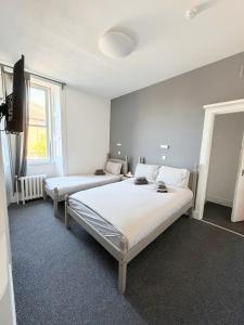 a bedroom with two beds and a television in it at The Windsor Hotel and Bar in Kirkcaldy +33 photos