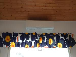 a window with a curtain with flowers on it at Holidayhome RintintinTahko in Tahkovuori