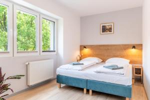 a bedroom with a bed and two windows at APARTAMENTY ZDROJOWA 9 in Duszniki Zdrój