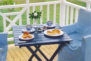 une table bleue avec deux assiettes de nourriture dans l'établissement Whitsunday Cane Cutters Cottage, à Cannon Valley