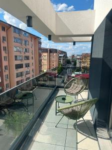 a balcony with chairs and a table on a building at Luxury Studio Chiajna in Roşu