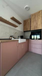 a kitchen with pink cabinets and a sink at Eirene Residence in Vrnjačka Banja