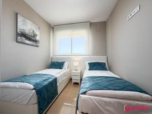 two beds in a small room with a window at Sunwave in Cabanes