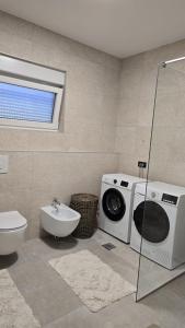 ein Badezimmer mit Waschmaschine und Waschbecken in der Unterkunft Apartman Anđa in Široki Brijeg + 15 Fotos