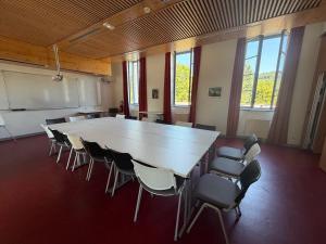 a large conference room with a large table and chairs at L'Eden du Forez in Le Brugeron +29 photos