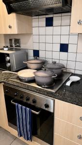 a kitchen with three pots and pans on a stove at Mapungubwe Hotel in Johannesburg