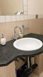 a bathroom counter with a white sink and a mirror at Mapungubwe Hotel in Johannesburg +1 photo