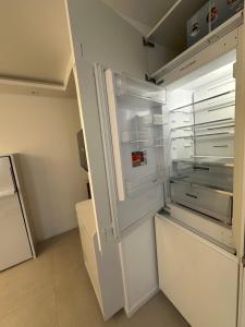 an empty refrigerator with its door open in a kitchen at Studio du Lac in Créteil