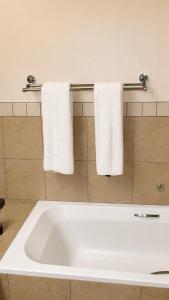 a bathroom with a large white tub and towels at Mapungubwe Hotel in Johannesburg