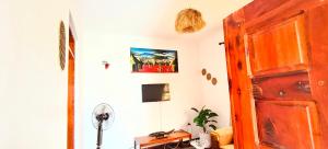 a room with a wooden door and a fan at Dans place in Moshi