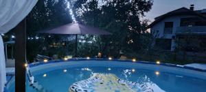 a swimming pool at night with an umbrella and a chair at Apartman Atelier in Karlovac