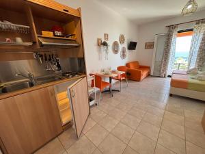 a kitchen and living room with a couch and a table at Studios Edem in Agios Ioannis Kaspaka