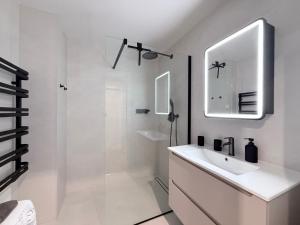 a white bathroom with a sink and a shower at Apartman H4 in Žilina +3 photos