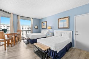 a hotel room with two beds and a table and chairs at Gorgeous and well appointed efficiency with shared pool and beach access in Destin