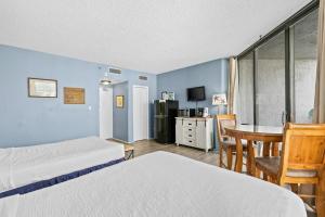 a hotel room with two beds and a table and a kitchen at Gorgeous and well appointed efficiency with shared pool and beach access in Destin