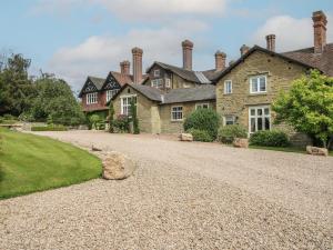 an old stone house with a gravel driveway at The Old Nursery in Much Wenlock