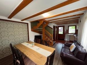 a dining room with a table and a leather couch at Hanga Apartments in Sovata
