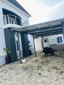 a patio with awning and a table in front of a house at DAS Apartments Lugbe in Abuja +2 photos