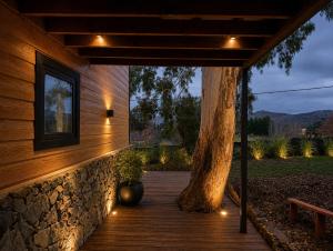 a wooden walkway with a tree on the side of a building at Cabañas Valle de los Ciervos in Tandil