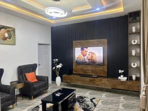 a living room with a flat screen tv on a wall at DAS Apartments Lugbe in Abuja