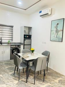 a kitchen and dining room with a table and chairs at DAS Apartments Lugbe in Abuja