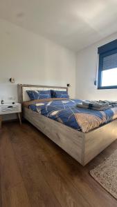 a large bed in a bedroom with a wooden floor at Eirene Residence in Vrnjačka Banja