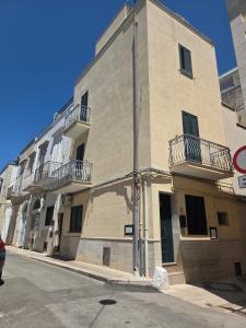 a building with balconies on the side of a street at Suite 93 in Mola di Bari