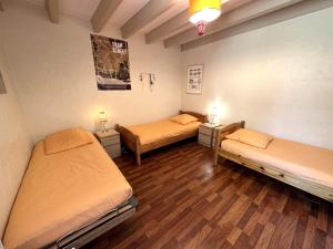 two beds in a room with wooden floors at Escapeteu in Azur