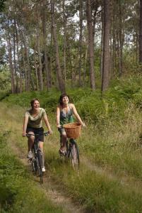 two women riding bikes down a trail in the woods at Escapeteu in Azur