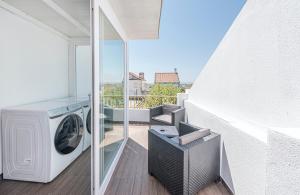 a balcony with a washer and dryer in a house at Solar da Fé in Atalaia