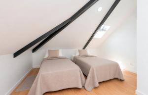 two beds in a room under the stairs at Solar da Fé in Atalaia