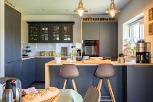 a kitchen with blue cabinets and a counter with stools at L'Oasis d'Yza in Gedinne +37 photos