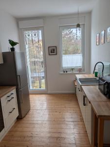 a kitchen with a refrigerator and a wooden floor at Zimmervermietung an der Bebra in Sondershausen