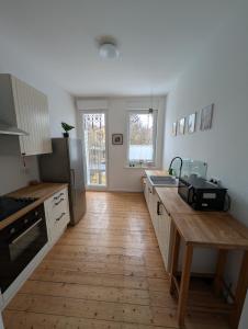 a kitchen with a wooden floor and a counter top at Zimmervermietung an der Bebra in Sondershausen