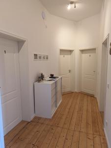 an empty kitchen with white walls and wooden floors at Zimmervermietung an der Bebra in Sondershausen +7 photos
